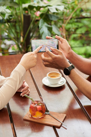 Hands of people pointing at map on smartphone when deciding where to meet next time