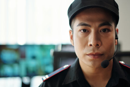 Portrait of serious Asian security guard of bank looking at cameraの写真素材