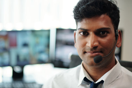 Portrait of smiling security manager standing in surveillance roomの写真素材