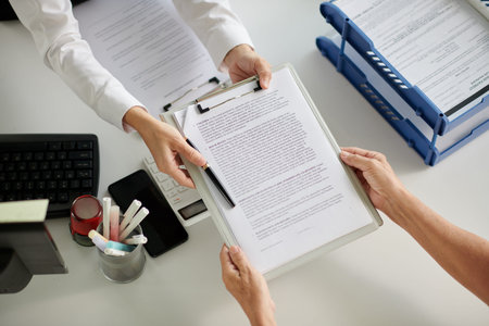 Social worker giving agreement to senior woman, view from above