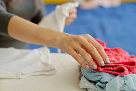 Closeup image of mother ironing clothes for her daughterの写真素材