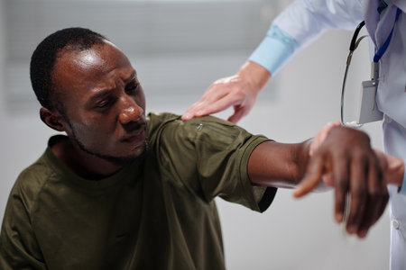 African American soldier with injured arm visiting doctor in military hospitalの写真素材