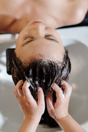 Young woman having her hair washed in beauty salonの写真素材