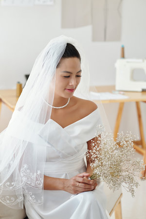 Beautiful bride with small bouquet waiting for groomの写真素材