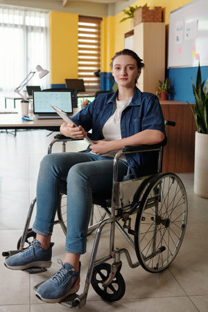 Portrait of young woman with disability working in officeの写真素材