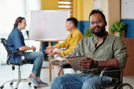 Portrait of positive Indian entrepreneur writing down plan for the daysの写真素材