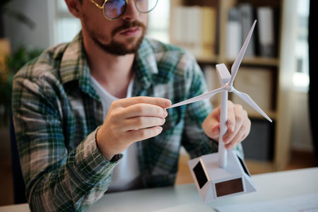Engineer holding model of plastic wind turbineの写真素材