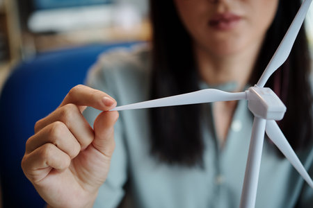 Closeup image of woman touching blate of small plastic wind turbineの写真素材