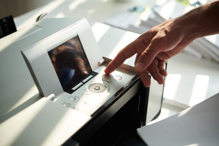 Businessman pressing button on printer to print reports for meetingの写真素材