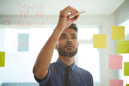 Ambitious young businessman writing creative ideas on glass wallの写真素材