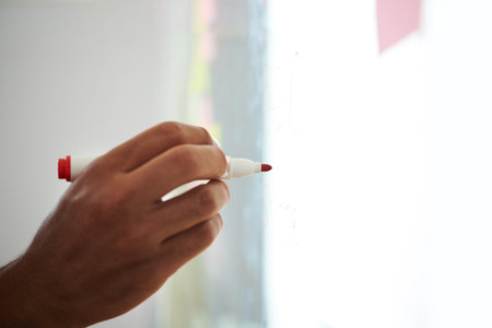 Closeup image of entrepreneur drawing diagram on glass wall for brainstorming sessionの写真素材
