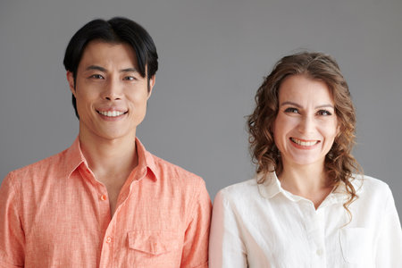 Happy diverse couple standing next to each other and smiling at cameraの写真素材
