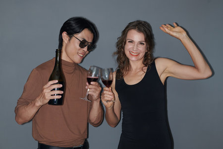 Joyful people drinking wine and dancing at birthday partyの写真素材