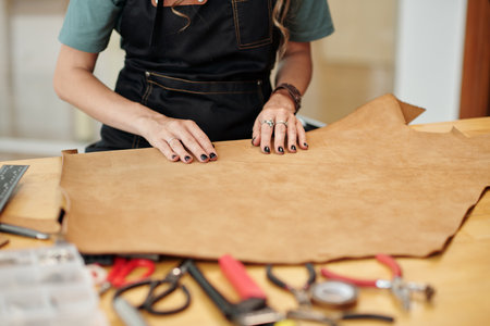 Creative young woman working with leather in her workshopの写真素材