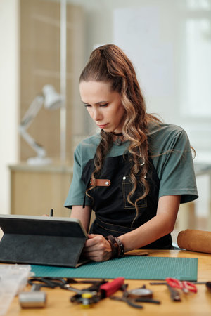 Creative young woman drawing sketch of new product on tablet computer