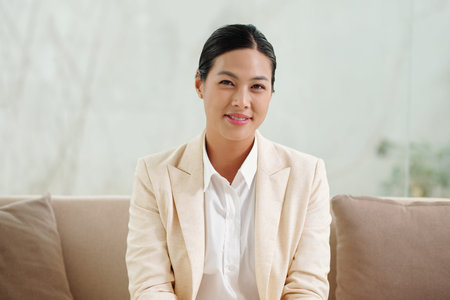 Portrait of smiling mental health counselor sitting on couch in her office