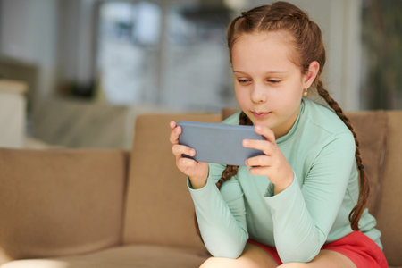 Joyful girl playing game or watching entertaining video on smartphone