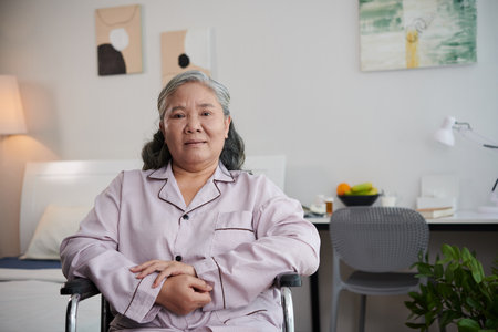 Aged woman spending time in nursing home bedroomの写真素材