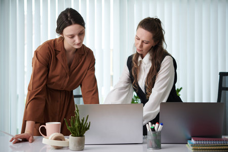 Businesswoman helping colleague with presentation of new strategy