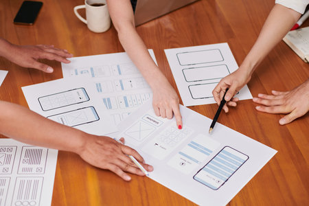 Closeup image of project manager and ui and ux designers discussing ideas for new interface