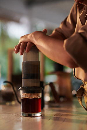 Closeup image of coffeeshop barista using aeropress when making coffee cupの写真素材