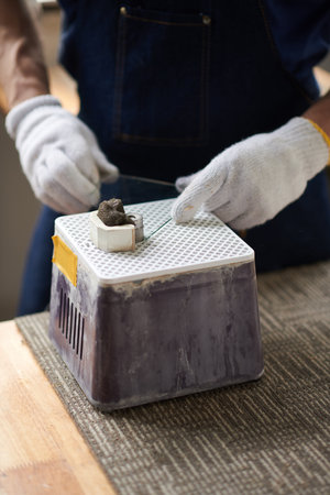 Worker polishing edges of glass piece for artistic projectの写真素材