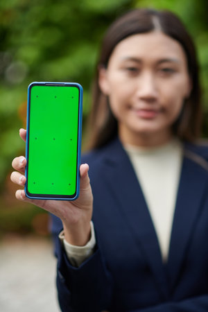 Smartphone with green screen in hand of female entrepreneurの写真素材