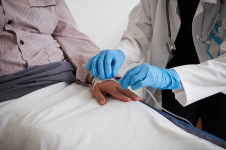 Closep image of doctor in medical gloves inserting IV catheterの写真素材