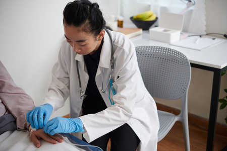 Doctor inserting IV catheter to deliver medication or fluids to patient