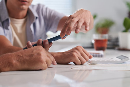 Young man showing father mobile application for controlling personal financesの写真素材