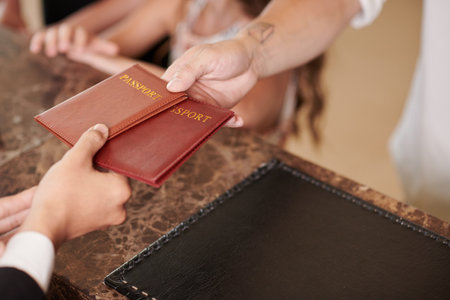 Hotel guests giving passports to hotel receptionist when checking inの写真素材