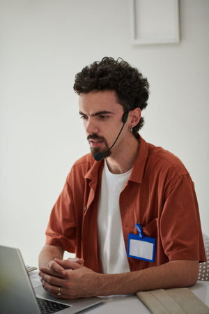Portrait of frowning QA engineer helping client to resolve issue