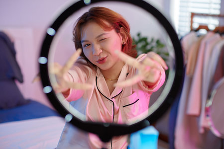 Transgender woman using ring light when filming blog for her subscribers