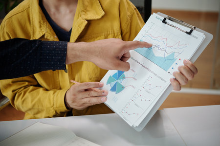 Closeup image of business people discussing report showing activity of company and subdivisionsの写真素材