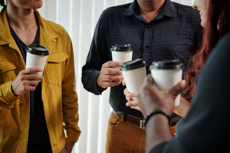 Cropped image of business people drinking take out coffee and talkingの写真素材
