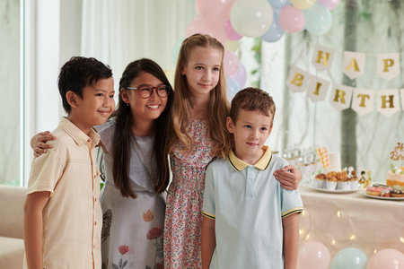 Group of children hugging when posing for photo at birthday party