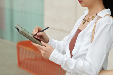 Cropped image of business lady filling document on tablet computerの写真素材