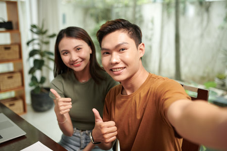 Smiling teenage college student taking selfie with girlfriendの写真素材