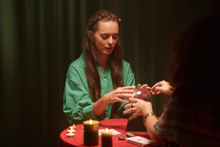 Woman visiting future teller, she is touching crystall ball to learn her future