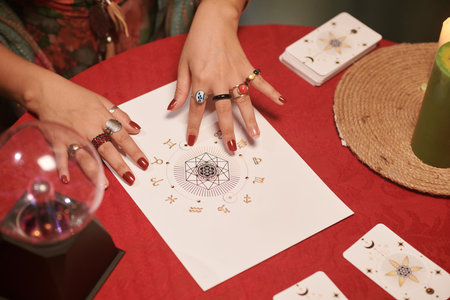 Manicured hands of astrologer checking natal chart of clinetの写真素材