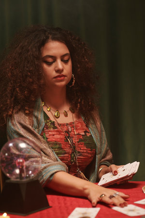 Portrait of serious fortune teller spreading cards in front of herの写真素材
