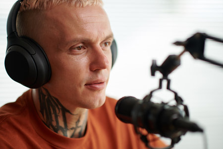 Portrait of radio show host speaking in microphoneの写真素材