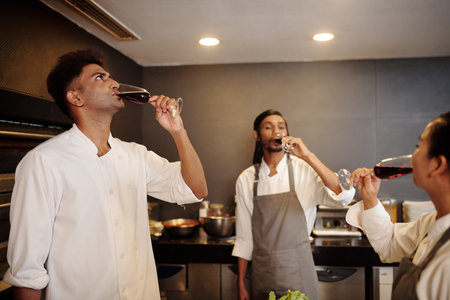 Restaurant cooks drinking wine after finishing shift at wedding celebrationの写真素材