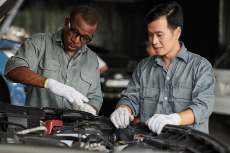 Car mechanics discussing the best way to repair engineの写真素材