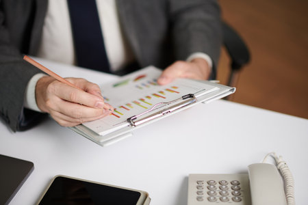Closeup image of analyst checking data in reports before meetingの写真素材