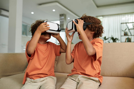 Siblings playing game in virtual reality glasses at homeの写真素材