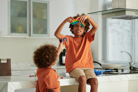 Creative kids playing with moulding clay and making rainbowの写真素材