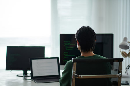Software developer programming on computer at his office desk
