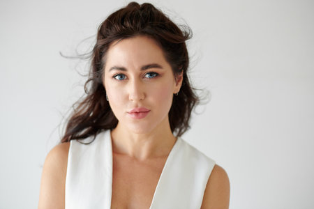 Studio portrait of young brunette with deep blue eyes looking at cameraの写真素材