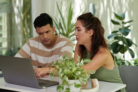 Young couple booking flight online when planning vacation